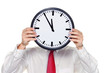 Manager im Stress mit Uhr vor Kopf.