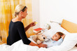 Mutter und krankes Kind im Bett.