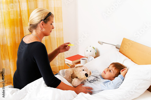 Foto: Mutter und krankes Kind im Bett. Mutter und krankes Kind im Bett.