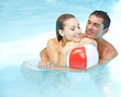 Paar mit Wasserball entspannt im Pool