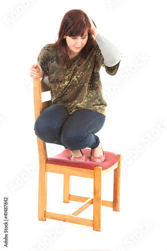 Foto: frightened overweight gir on the chair, full length frightened overweight gir on the chair, full length