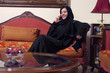 arabian lady wearing hijab talking on mobile at home