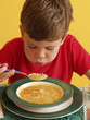 Niño comiendo sopa con fideos, niño almorzando. Niño comiendo sopa con fideos, niño almorzando.