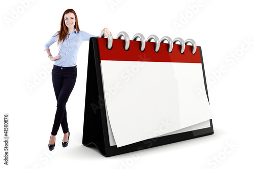 Photo: Attractive young business woman and a 3d blank calendar Attractive young business woman and a 3d blank calendar