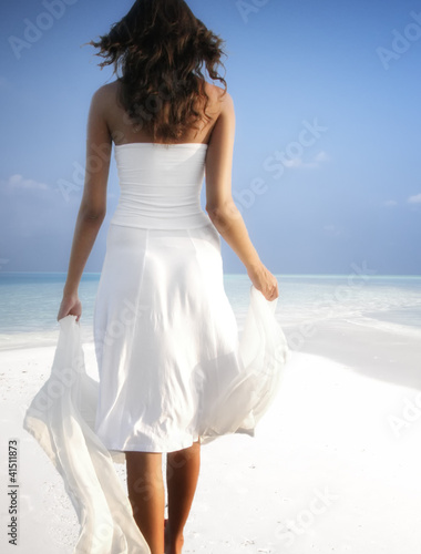 Foto: Girl walking on a white sandy beach on the Maldives (Malediven) Girl walking on a white sandy beach on the Maldives (Malediven)