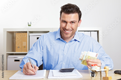 Foto: Mann mit Geld im Büro Mann mit Geld im Büro