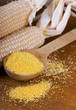 maize flour over spoon on a wooden table maize flour over spoon on a wooden table