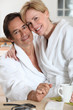 Couple dressed in bathing robes in the kitchen