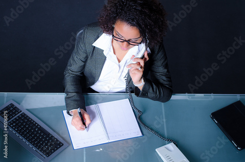 Foto: junge frau macht sich notizen beim telefonieren junge frau macht sich notizen beim telefonieren