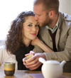 Couple is drinking tea in the living room.