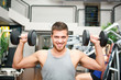 Young man lifting weights in the gym