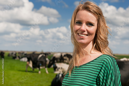 Photo: Dutch girl in field with cows Dutch girl in field with cows