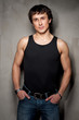 Photo: Portrait of a handsome young man standing with gray wall Portrait of a handsome young man standing with gray wall