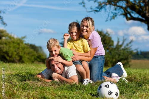 Photo: Familie mit Kindern und Fußball auf einer Wiese Familie mit Kindern und Fußball auf einer Wiese