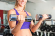 Sport - Frau trainiert mit Hanteln im Fitnessstudio Sport - Frau trainiert mit Hanteln im Fitnessstudio