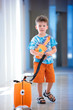 A cute little boy with orange suitcase