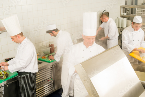 Photo: Professional kitchen busy team cooks and chef Professional kitchen busy team cooks and chef