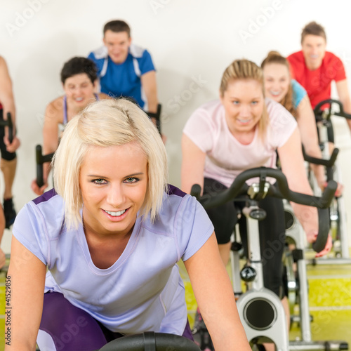 Photo: Fitness young woman on gym bike spinning Fitness young woman on gym bike spinning