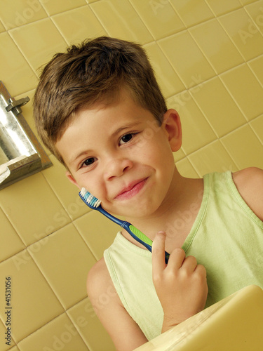 Photo: Niño cepillándose los dientes en un baño. Niño cepillándose los dientes en un baño.