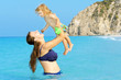 Young and happy toddler girl playing with her mother at the beac