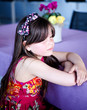 Thoughtful brunette child girl sitting at a table in restaurant