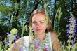 beautiful young woman between flowers in a garden