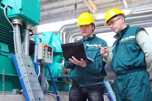 Photo: Industrial workers with notebook, teamwork Industrial workers with notebook, teamwork