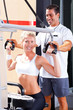 personal trainer helping client in gym