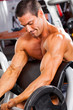 muscular man training with barbell in gym