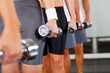group of people with dumbbells in gym