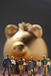 Eine Gruppe Personen vor einem goldenen Sparschwein