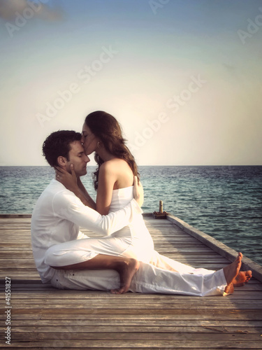 Foto: Beautiful love couple on a jetty by the sea (Maldives) Beautiful love couple on a jetty by the sea (Maldives)