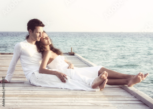 Photo: Beautiful love couple on a jetty by the sea (Maldives) Beautiful love couple on a jetty by the sea (Maldives)