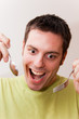 Young man with spoon and fork
