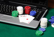Gambling chips and poker cards on a laptop