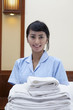 Photo: Hotel maid with towels posing in a hotel room Hotel maid with towels posing in a hotel room