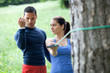 Perosonal trainer working with his client, showing her how to pr