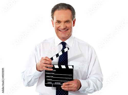 Photo: Aged corporate male holding clapperboard Aged corporate male holding clapperboard