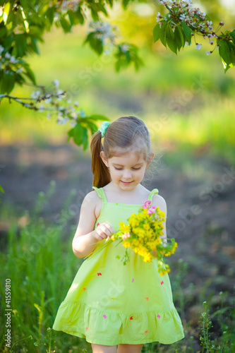 Photo: Adorable kid with bouquet of flowers in summer garden Adorable kid with bouquet of flowers in summer garden