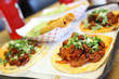 Al pastor soft tacos with taquitos at a local taqueria.