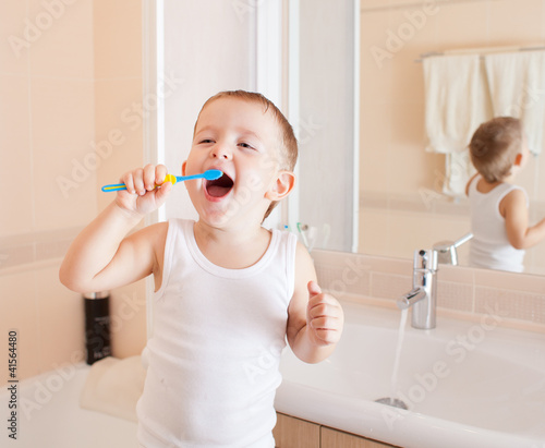 Photo: Boy cleaning teeth in bathroom Boy cleaning teeth in bathroom