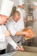 Two professional chefs cooking in kitchen
