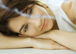 Young woman resting head on hands, looking at smoking incense
