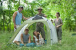 Young campers in and around tent, portrait