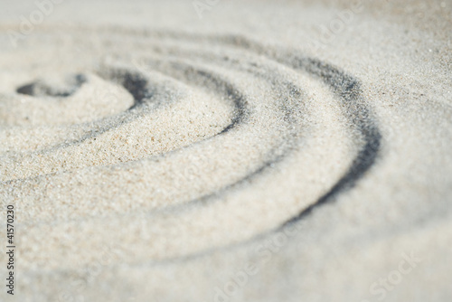 Foto: Spiral shape drawn in sand, close-up, surface level Spiral shape drawn in sand, close-up, surface level