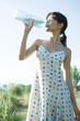 Young woman drinking from bottle of water, eyes closed