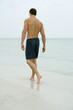 Man walking in surf, rear view