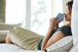 Photo: Woman sitting on sofa, holding up card and envelope to nose, smiling with eyes closed Woman sitting on sofa, holding up card and envelope to nose, smiling with eyes closed