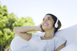 Teenage girl listening to headphones, looking up, smiling