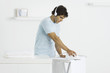 Man ironing towels, listening to headphones